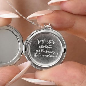 May include: Silver locket necklace with a quote engraved on the front: "To the stars who listen and the dreams that are answered".