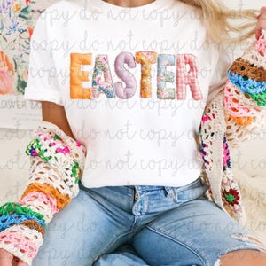 May include: A white t-shirt featuring the word "EASTER" in patchwork letters. The letters are in orange, floral, lavender, floral, blue, and pink plaid patterns. The person is wearing a colourful crochet cardigan and blue jeans.