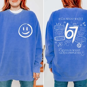 May include: A blue sweatshirt featuring a white smiley face on the front. The back of the sweatshirt has the text "IF 6 IS WHAT WE DO" and "SEVEN IS WHAT GOD COMPLETES" with the number "67" and other graphics. A casual, comfortable garment.