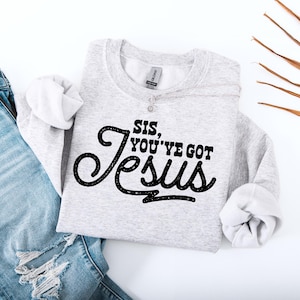 May include: A gray sweatshirt with the text "Sis, you've got Jesus" in black lettering.
