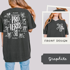 May include: A black t-shirt with a white graphic design featuring the words "PRO VERBS 31" surrounded by bows and inspirational phrases. The back of the shirt has a similar design with additional phrases like "Stay humble", "The Virtuous Wife", "Seek wisdom", "Be virtuous", "Keep serving", "Stay strong", "Stay diligent", "Be honest", "Be faithful", "Be disciplined", and "Seek the Lord".