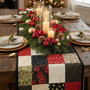 May include: A patchwork table runner featuring squares of red, black, cream, and olive green fabric with floral and swirl patterns. The runner is topped with a centerpiece of evergreen branches, red and gold ornaments, pinecones, and five pillar candles.