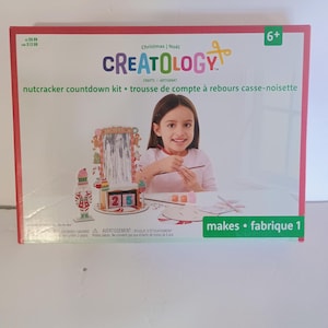Può includere: Un kit di conto alla rovescia a schiaccianoci Creatology, per bambini dai 6 anni in su, in una scatola rossa e bianca. La scatola mostra una bambina che crea, un display per il conto alla rovescia a schiaccianoci e il testo "Christmas | Noël".