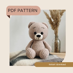 Op de afbeelding: Een gehaakte teddybeer in lichtbruin, met zwarte ogen en een witte snuit. De beer zit op een deken. De afbeelding bevat de tekst "PDF PATTERN" en "Instant download".