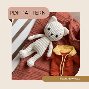 May include: A crocheted white cat doll with black eyes and a small orange jacket with a yellow collar. The words "PDF PATTERN" and "Instant download" are displayed on the image.