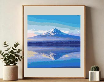 Op de afbeelding: Een ingelijste print van een berg die wordt weerspiegeld in een stil meer. De berg is bedekt met sneeuw en het meer is diepblauw. De lucht is lichtblauw met witte wolken.