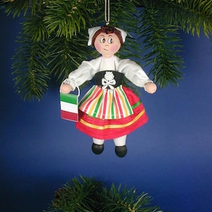 May include: A handmade Christmas ornament depicting a woman in traditional Italian clothing. She is holding a small Italian flag and wearing a red, green, and yellow striped skirt.