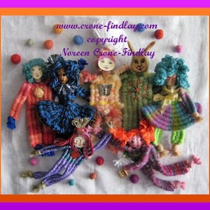 May include: A group of seven colorful, handmade dolls with yarn hair and embroidered faces. The dolls are wearing different outfits, including a red and white clown costume, a blue and white dress, a rainbow striped outfit, and a green and white dress. The dolls are arranged on a white fabric background with the text "www.crane-findlay.com copyright Noreen Crane-Findlay" at the top.