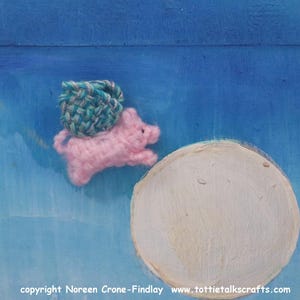 May include: A pink crocheted pig with a green and blue crocheted basket on its back flies over a white circle against a blue background. The text "copyright Noreen Crone-Findlay www.tottietalkcrafts.com" is at the bottom of the image.