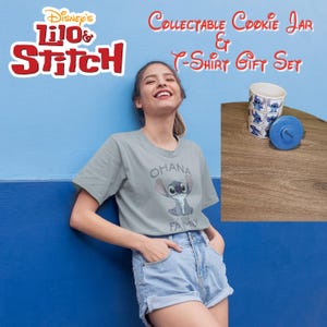 Pode incluir: Uma mulher vestindo uma camiseta cinza com um gráfico azul do personagem Stitch e o texto "Ohana means family" está em pé na frente de uma parede azul. Ela está segurando um pote de biscoitos azul com um design do personagem Stitch. O pote de biscoitos tem uma tampa azul com a palavra "Disney" nela. O texto "Disney's Lilo & Stitch Collectible Cookie Jar & T-Shirt Gift Set" é exibido na parte superior da imagem.