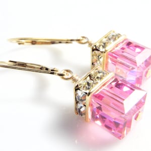 crystal cube dangle earrings in bright pink color with gold rhinestone crowns on top and set on gold leverback earring closures