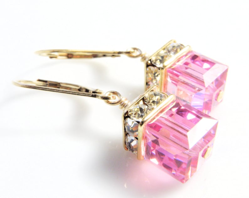 crystal cube dangle earrings in bright pink color with gold rhinestone crowns on top and set on gold leverback earring closures