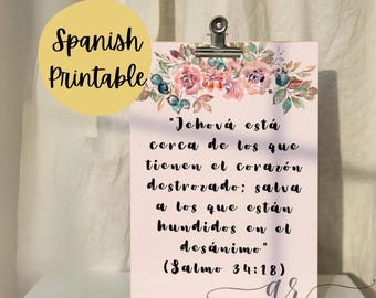 May include: A light pink printable with a floral design and the text "Jehová está cerca de los que tienen el corazón destrozado; salva a los que están hundidos en el desánimo" (Salmo 34:18). The words "Spanish Printable" are in a yellow circle.