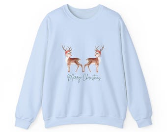 May include: Light blue sweatshirt featuring two reindeer wearing Santa hats. The reindeer are brown with white accents. The words "Merry Christmas" are written in a script font below the reindeer. A cozy holiday-themed sweatshirt.