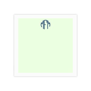 May include: A square notepad with a light green interior and a white border. The notepad features a navy blue monogram in a circular design at the top center. The monogram consists of the letters MFM.
