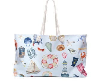 Puede incluir: Bolso de playa grande con un fondo azul claro con ilustraciones de acuarela de conchas marinas, gafas de sol, un velero, un faro y otros elementos temáticos de playa. El bolso tiene asas de cuerda blanca.