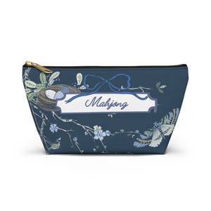 May include: A blue zippered pouch with a floral design and a white banner with the text "Mahjong".
