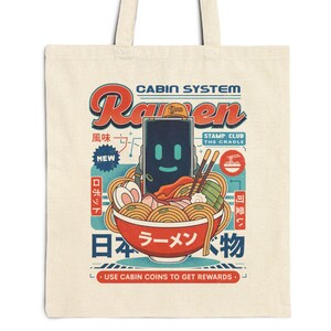 May include: Cream-colored tote bag featuring a colorful graphic design. The design includes the word "Raven" in a retro font, a bowl of ramen, and Japanese text. The bag has two handles for carrying.