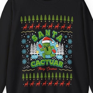 Puede incluir: Suéter navideño negro con un cactus verde que lleva un gorro de Papá Noel y el texto "Santa Cactuar" con los años "ESTD 1994".
