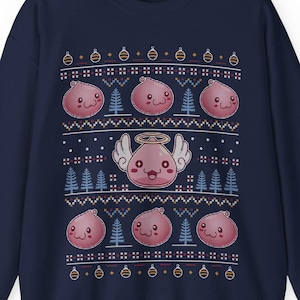 May include: A navy blue Christmas sweater with a festive design featuring pink and white cartoon characters with angel wings. The characters are surrounded by Christmas trees and ornaments.
