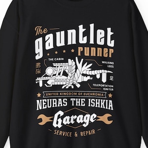 May include: Black sweatshirt with a white graphic design of a futuristic vehicle called "The Gauntlet Runner". The design includes the text "Neuras the Ishkia Garage - Service & Repair" and features a stylized illustration of the vehicle with details like "The Cabin", "Walking Legs", and "Teleportation Igniter".