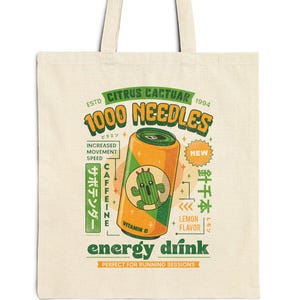 Puede incluir: Una bolsa de tela beige con un diseño gráfico de una lata de bebida energética amarilla y naranja con un cactus verde en ella. El texto en la lata dice "Citrus Cactuar 1994 1000 Needles" y "energy drink".