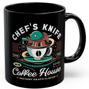 Puede incluir: Taza de café de cerámica negra con la inscripción "Chef's Knife Coffee House" y un dibujo de un chef en una taza de café. La taza tiene un interior blanco y un asa negra.