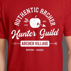 May include: Red t-shirt with a white graphic design. The graphic features a stylized apple with an arrow through it, the text "Authentic Archer Hunter Guild", and the text "Archer Village Payon - Hugel".
