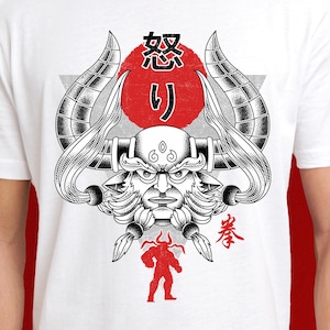 Puede incluir: Camiseta blanca con una ilustración en blanco y negro de un demonio con cuernos y un círculo rojo con los caracteres japoneses "怒り". El texto "拳" está en la esquina inferior derecha.