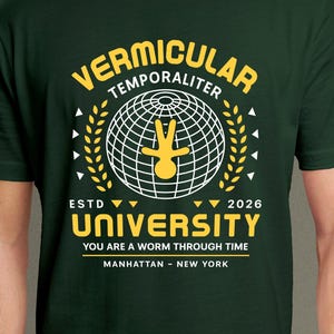 Puede incluir: Una camiseta de manga corta de color verde oscuro con un gráfico en amarillo y blanco. El diseño incluye un icono de globo terráqueo con una figura central, el texto "VERMICULAR TEMPORALITER UNIVERSITY", "ESTD 2026", "YOU ARE A WORM THROUGH TIME" y "MANHATTAN - NEW YORK".