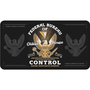 May include: Black rectangular desk mat featuring the text "FEDERAL BUREAU OF CONTROL" in a vintage design. The mat includes an eagle emblem, the words "Oldest House", and the text "CONTROL". The mat is designed for a desk.