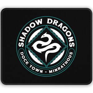 May include: Black mousepad with a white circle containing a white dragon with a teal chain border. The circle has the text "Shadow Dragons Dock Town - Minrathous" in white.