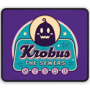 May include: A purple mousepad with a retro-style logo for "Krobvus The Sewers Store". The logo features a cartoon ghost with a yellow halo and a teal background.