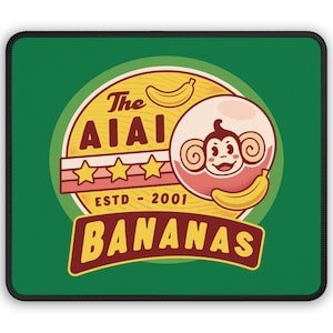 Może przedstawiać: Zielona podkładka pod mysz z żółto-czerwonym logo. Logo przedstawia kreskówkową małpę z bananem, tekst "The Aiai Bananas", trzy gwiazdki i tekst "ESTD - 2001".