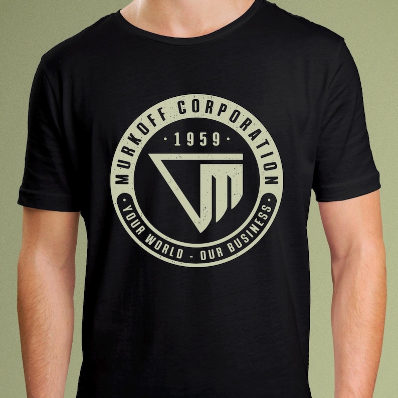 May include: Black t-shirt with a white circle graphic featuring the text "Murkoff Corporation - 1959 - Your World - Our Business" and a stylized "VM" logo.