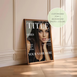 Op de afbeelding: Een ingelijste magazinecover met een portret van een vrouw. De titel van het tijdschrift is "TITLE" in grote witte letters. Andere tekst bevat "ARIES", "AVANT GARDE" en "YOUR NAME HERE". De lijst is bruin en de achtergrond is een lichtgekleurde muur en een houten vloer.