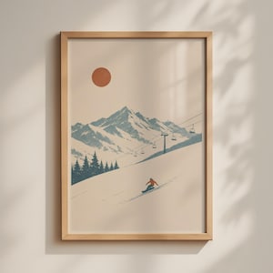 May include: A framed wall art print featuring a snowy mountain landscape with a chairlift, a cluster of pine trees, and a lone snowboarder in an orange jacket. A solid terracotta-colored circle represents the sun in a pale beige sky.
