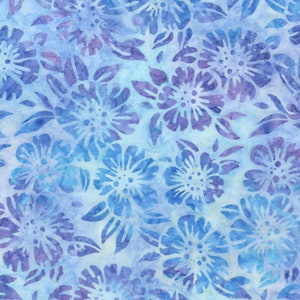 May include: A fabric with a floral pattern in shades of blue and purple. The design features stylized flowers and leaves against a light blue background. The flowers have a detailed, batik-like appearance, creating a textured look.