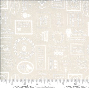 May include: Beige fabric with a repeating pattern of white framed text and illustrations. The text includes phrases like "Butterfly's Creamery," "Honeybee Bakery," and "Sunny's Flower Shoppe." The fabric also features a ruler along the bottom edge.
