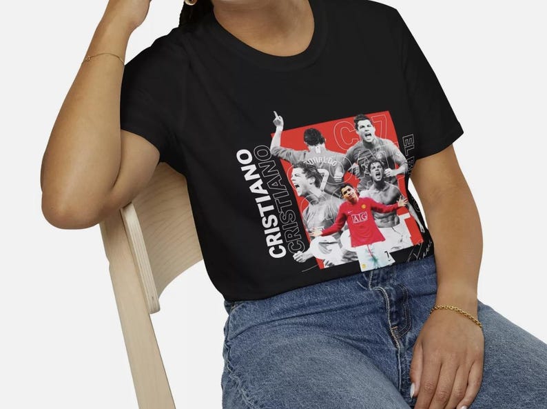 May include: Black t-shirt featuring a collage of Cristiano Ronaldo in action, with the name "CRISTIANO" in white text. The design includes images of Ronaldo in a red jersey and other action shots.
