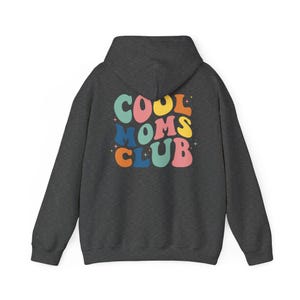 May include: A dark gray hooded sweatshirt with the text "COOL MOMS CLUB" in colorful retro lettering on the back.