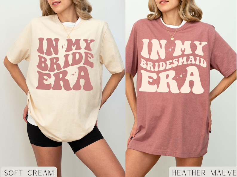 May include: Two oversized t-shirts with the text "In My Bride Era" and "In My Bridesmaid Era" in a retro font. The shirts are in soft cream and heather mauve colors.