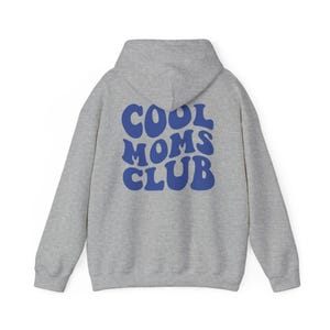 May include: Gray hooded sweatshirt with the text "COOL MOMS CLUB" in blue, retro-style lettering on the back.