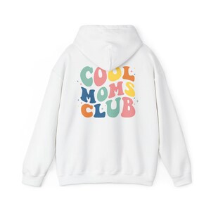 May include: White hooded sweatshirt with the text "COOL MOMS CLUB" in colorful retro lettering on the back.