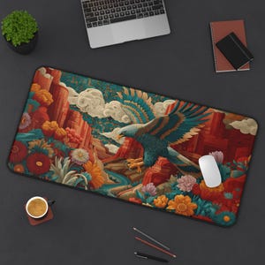 May include: A rectangular desk mat featuring a vibrant illustration of an eagle soaring over a canyon landscape with flowers. The color palette includes shades of red, orange, teal, and blue. A white mouse rests on the mat.