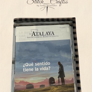 May include: A clear plastic magazine holder with a plaid fabric border. The holder contains a magazine with the title "LA ATALAYA" and the question "¿Qué sentido tiene la vida?" printed on the cover. The top of the image has the text "Stitch Craftss by Isabel Hernandez".