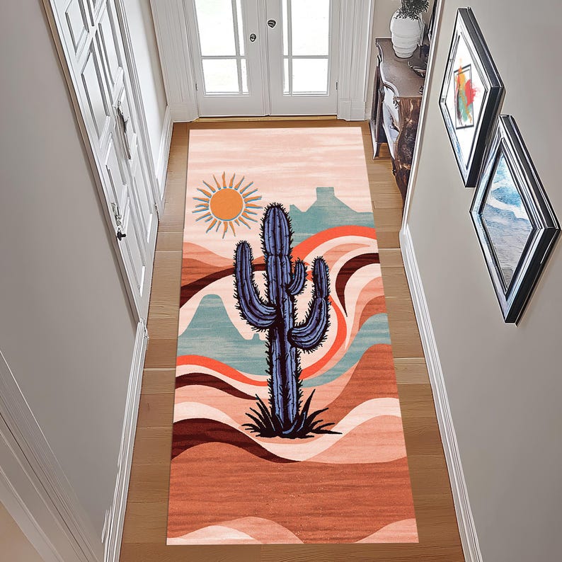 May include: A rectangular area rug with a desert landscape design. The rug features a large blue cactus, a yellow sun, and a colorful background with mountains and wavy lines in shades of orange, brown, and teal.