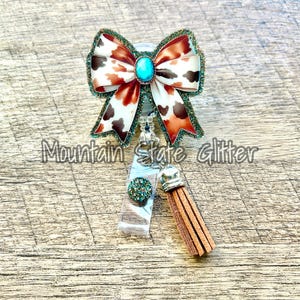 Carrete de insignia acrílico con lazo y estampado de vaca marrón