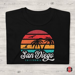 May include: Black t-shirt with a vintage-style graphic of a sunset over palm trees and the text "San Diego, California".