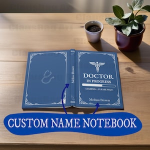 Puede incluir: Una libreta azul con una barra de progreso de "Doctor en progreso" y el texto "DOCTOR EN PROGRESO" y "CARGANDO... ESPERE POR FAVOR". La libreta tiene un borde blanco y un estetoscopio en el lado izquierdo. El nombre "Melissa Brown" está escrito en las portadas delantera y trasera.